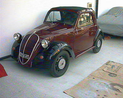 Una Fiat 500 Topolino amaranto Oggi la benzina rincarata l'estate del